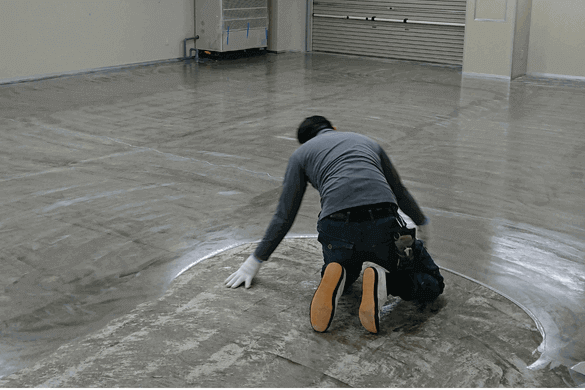 塗床工事の中塗り施工中の作業員